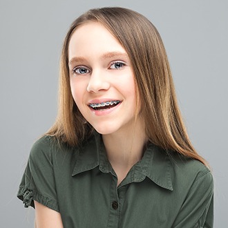 Preteen girl smiling with pediatric orthodontic appliance in place
