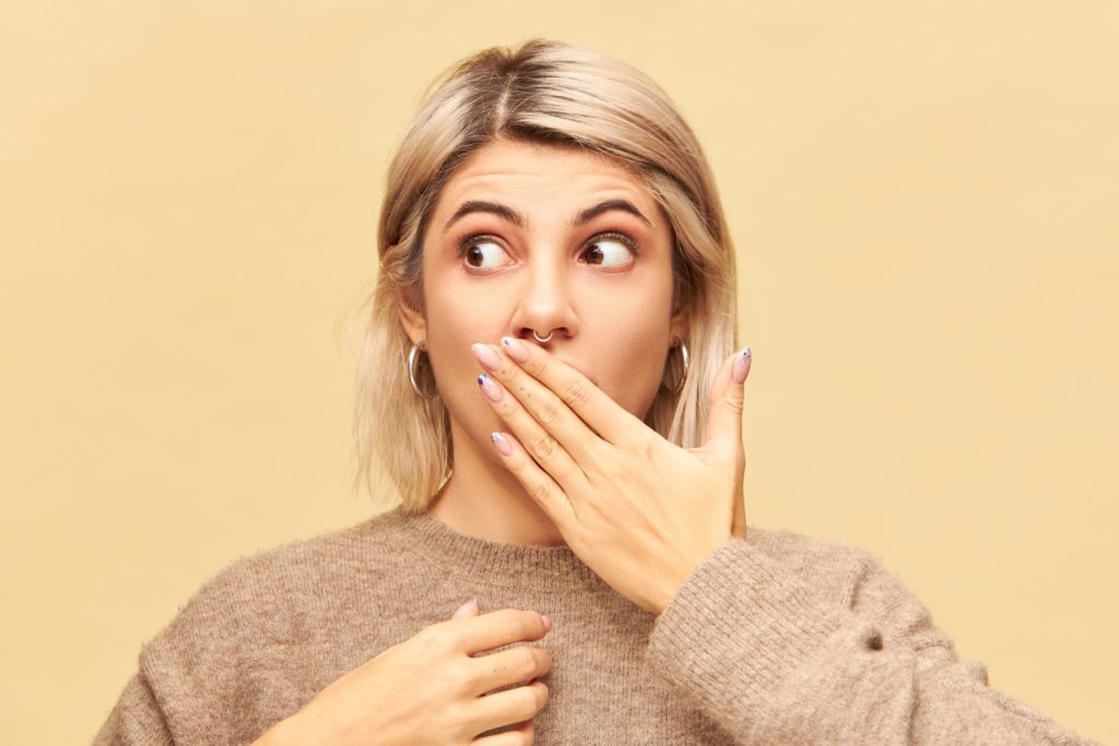 Closeup of woman covering her mouth in shock